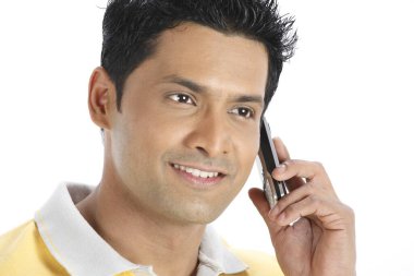 Cep telefonunu sol kulağına dayayıp konuşan kendinden emin genç bir adam. 