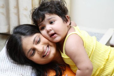 Bir buçuk yaşındaki bir çocuğun annesi ve bebeği  