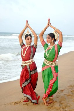 Dancers performing classical traditional odissi dance in front of bay of Bengal sea, Konarak, Orissa, India  clipart