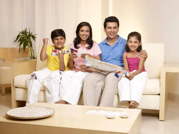 stock image Children with parents looking at booklets and maps sitting in house 