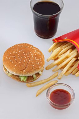 Fast food, sebze burger, patates kızartması sosu ve beyaz arka planda kakao kola. 