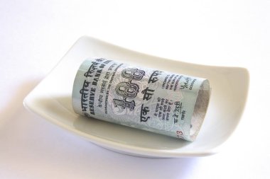 Concept Indian currency one hundred rupees in plate