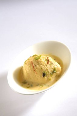 Hindistan tatlısı, kesar rasmalai garnitürü şam fıstığı ve safranla servis edilir.