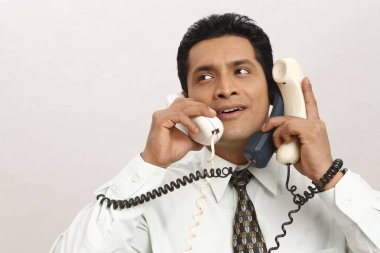 İş adamı üç telefon görüşmesi yapıyor. 