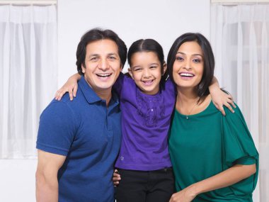 Ailesi ve kızı evde birlikte poz veriyorlar.