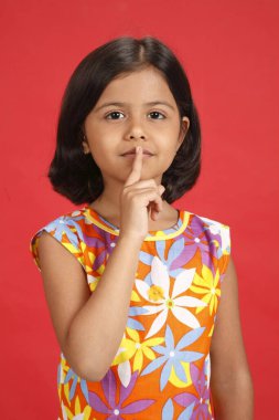 Sekiz yaşındaki kız sağ işaret parmağını dudaklarında tutuyordu. 