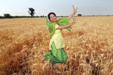 Sih kadın buğday tarlasında halk dansı yapıyor. 