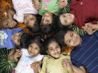 Çocuklar arka planda havai fişek atarak el ele tutuşuyorlar.  