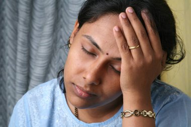 Güney Asyalı genç bayan hayal kırıklığına uğramış ve acı içinde görünüyor.