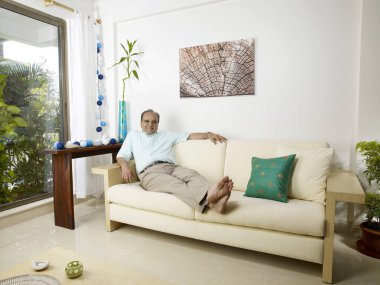 Kanepede oturan yaşlı adam. 