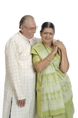 Old happy couple standing close to each other and hugging  clipart