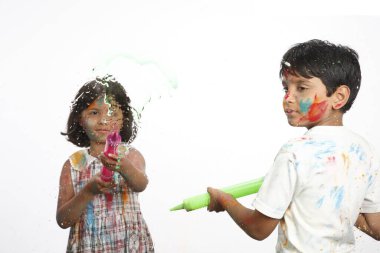 Ten and eight year old boy and girl want to spray water colors on glass with help of big plastic syringe  clipart