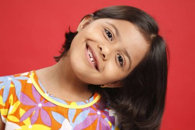 Sekiz yaşında bir kız başını sola eğmiş. 