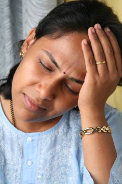 Güney Asyalı genç bayan hayal kırıklığına uğramış ve acı içinde görünüyor.