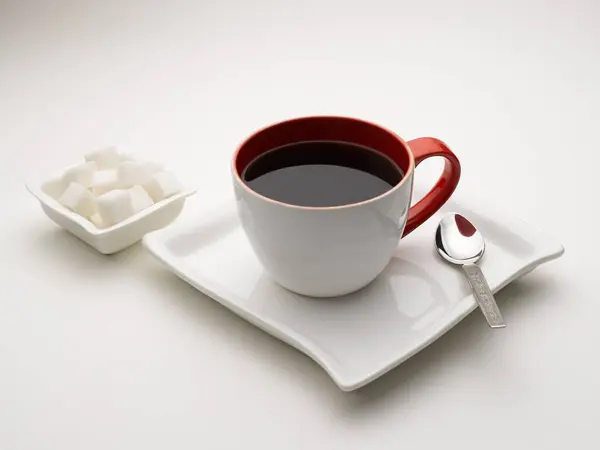 stock image mug of black tea in serving plate with sugar cubes India