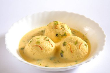 Hindistan tatlısı, kesar rasmalai garnitürü şam fıstığı ve safranla servis edilir.