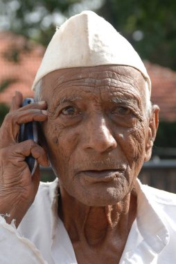 Cep telefonlu taşralı yaşlı adam, Lonavala, Maharashtra, Hindistan 