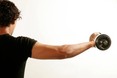 South Asian Indian man wearing black T_shirt and curly oily hair building arms muscles with steel dumbbell clipart