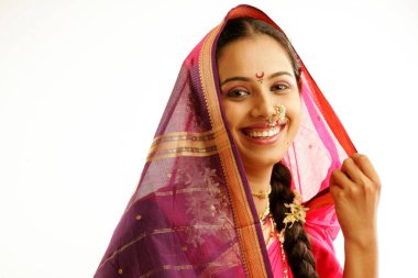 Güney Asyalı Maharashtrian kızı geleneksel Navwari elbisesi takıyor. Dokuz yarda sari, uygun mücevherler ve ellerinde ghunghat tutan gajra denilen çiçeklerden oluşan bir çelenk. 