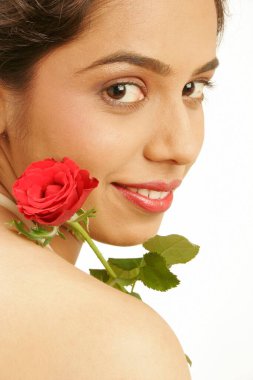 Güney Asyalı genç kız elinde kırmızı gül tutuyor. 