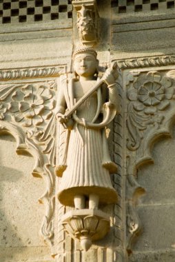 Müzikal enstrümanlı ve vücudunda yılan kobrası olan bir adam Maheshwar Tapınağı, Maheshwar, Madhya Pradesh, Hindistan 'ın duvarına kazınmış.