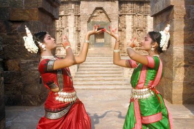 Dancers performing classical traditional odissi dance in front of Sun Temple, Konarak, Orissa, India  clipart