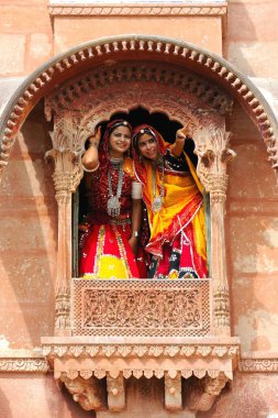 Rajasthani ladies looking through jharoka , Rajasthan , India clipart