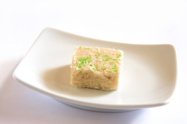 Hint bonbonu şekerlemesi mithai sohan papadi büyüleyici gevrek kek güzel bir tatlı tabakta servis edilir