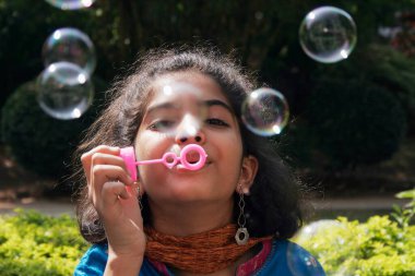 10 yaşındaki Guajarati kızı sabun köpüğü üflüyor.