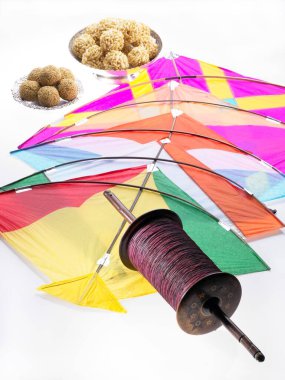 Renkli beş uçurtma Makara Sankranti festivalinde susamlı pirinç laddoo ile iple manja ipliği 