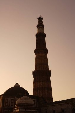 Alai Darwaza İmam Zamin mezarı ve Kutup Minar 'da günbatımı 1311 yılında inşa edilen kırmızı kumtaşı kulesi, Hindistan _ Müslüman sanatı, Delhi sultanlığı, Delhi, Hindistan UNESCO Dünya Mirası