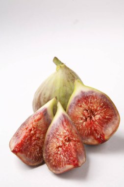 Meyveler, İncir Ficus Carica Anjir. Biri dolu, diğeri üç parçaya bölünmüş. Beyaz arka planda kırmızı sulu doku.