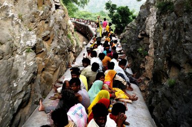 Trenin çatısında oturan yolcular uçurumdan geçiyorlar, Kemali Ghat, Rajasthan, Hindistan 
