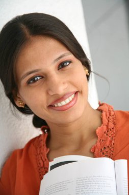 Güney Asyalı genç bayan kitap tutuyor. 