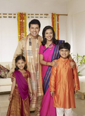 Parents with children in traditional wearing standing in house  clipart