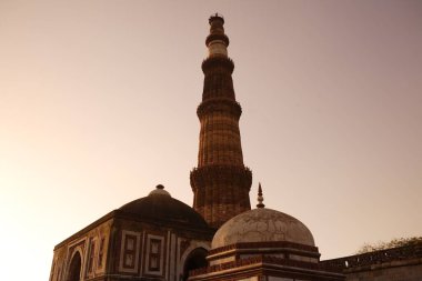 Alai Darwaza İmam Zamin mezarı ve Kutup Minar 'da günbatımı 1311 yılında inşa edilen kırmızı kumtaşı kulesi, Hindistan _ Müslüman sanatı, Delhi sultanlığı, Delhi, Hindistan UNESCO Dünya Mirası