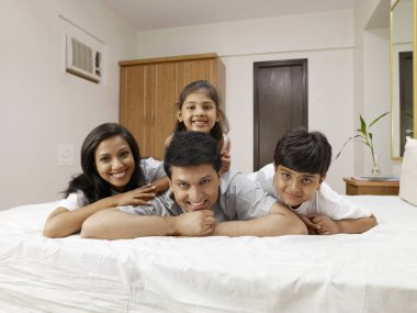 Çocuklu ebeveynler yatak odasında yatıyorlar.