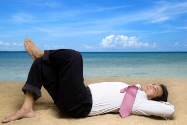 Yönetici deniz kıyısında kumda dinleniyor