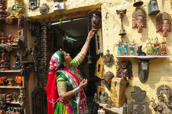 stock image Lady in colourful traditional dress looking at handicraft items, Jaisalmer, Rajasthan, India   