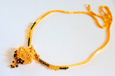 Beyaz arkaplanda siyah ve altın boncuklu kolye 