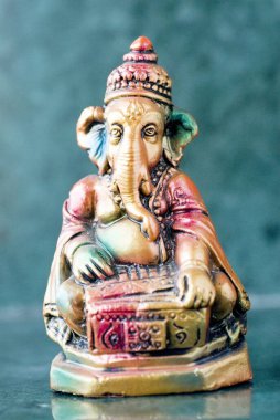 Lord Ganesha ganpati alçı Idol rengarenk bir şekilde oturmuş armonyum Hint müziği enstrümanı çalıyor.