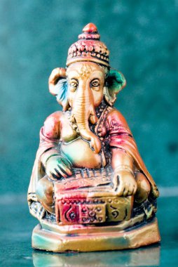 Lord Ganesha ganpati plaster Idol sitting colourful playing harmonium Indian musical wind Instrument clipart