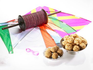 Renkli beş uçurtma Makara Sankranti festivalinde susamlı pirinç laddoo ile iple manja ipliği 