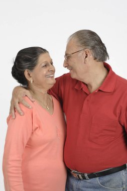 Yaşlı bir çift, yaşlı bir adam yaşlı bir kadını tutuyor ve birbirlerine bakıyorlar. 