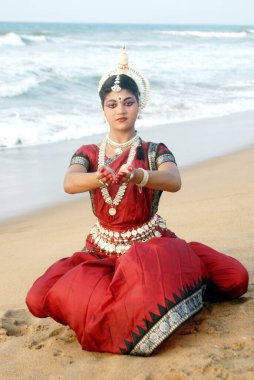 Dansçı geleneksel Odissi dansını Bengal Körfezi, Konarak, Orissa, Hindistan 'da yapıyor. 