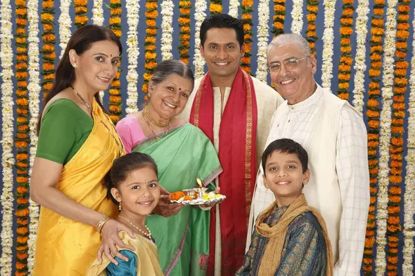 Stock image Grandmother holding aarti thali and family looking 