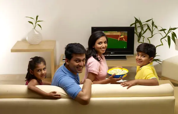 Stock image Children with parents looking at camera sitting in house 