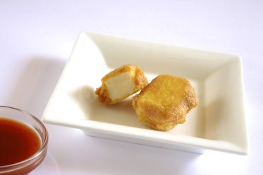 Hint mutfağı, fast food aperatifleri beyaz arka planda domatesli ketçapla servis edilen peynirli paketler.