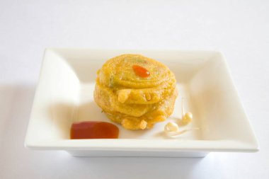 Hint mutfağı, fast food aperatifleri Moong Vada böreği Phaseolus Aureus beyaz arka planda domates ketçapıyla servis edilir. 