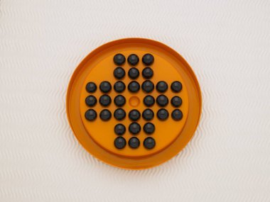 Beyaz arka planda siyah fasulyeli turuncu tabağın üst görüntüsü